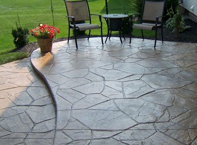 Stamped concrete patio with one step in a slate finish.