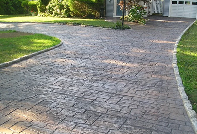Old and weathered stamped concrete driveway.