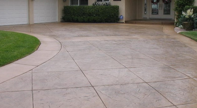 Stamped concrete driveway stained and cut to resemble large tiles.