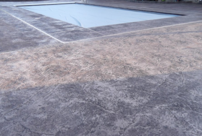 Gray textured stamped concrete pool deck in Michigan.