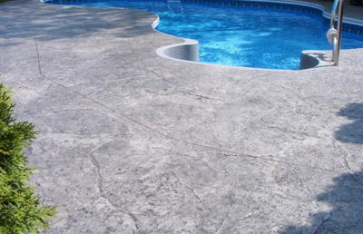 Stamped and stained concrete pool deck around built in pool