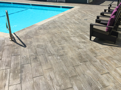 Pool deck with wood plank stamped concrete.